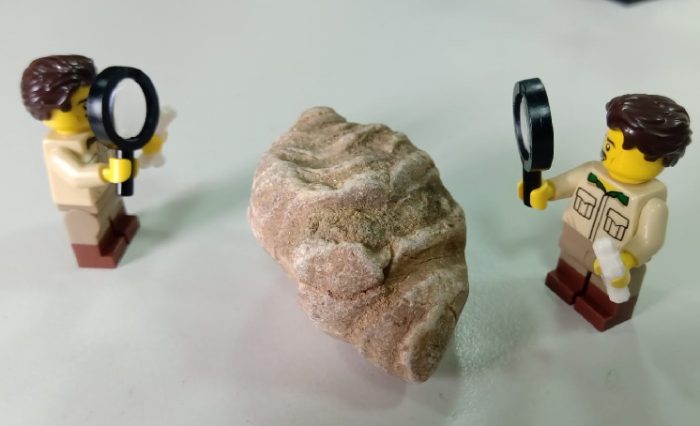 figurine de lego analizând o rocă, fotografie ilustrație știre geoparc lego