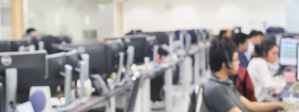 Blurred,Of,Employee,Working,Call,Centre,Hotline,At,Office,Computer
